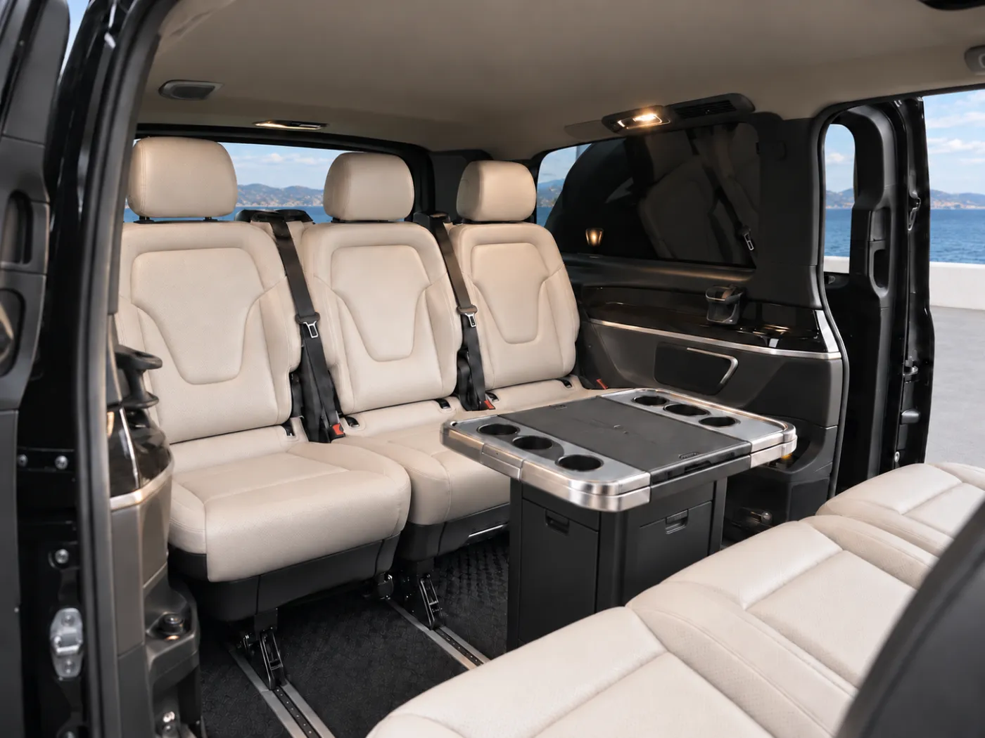 Two facing rows of three ivory leather passenger seats inside a Mercedes-Benz V-Class