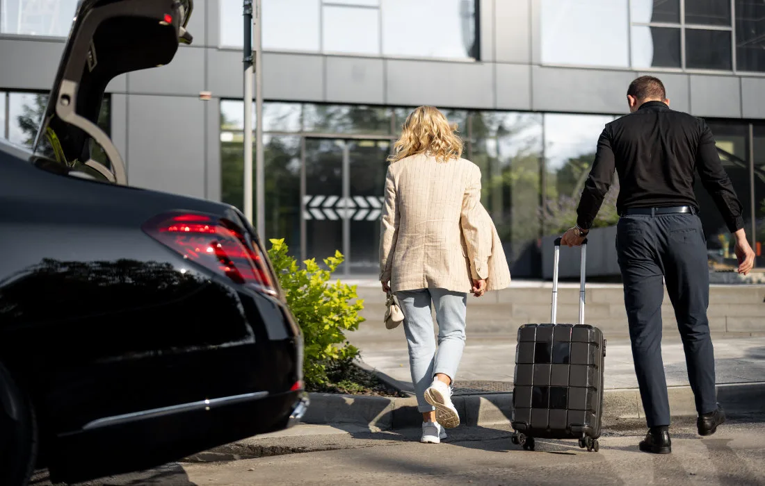 Chauffeur helps a businesswoman to carry her suitcase